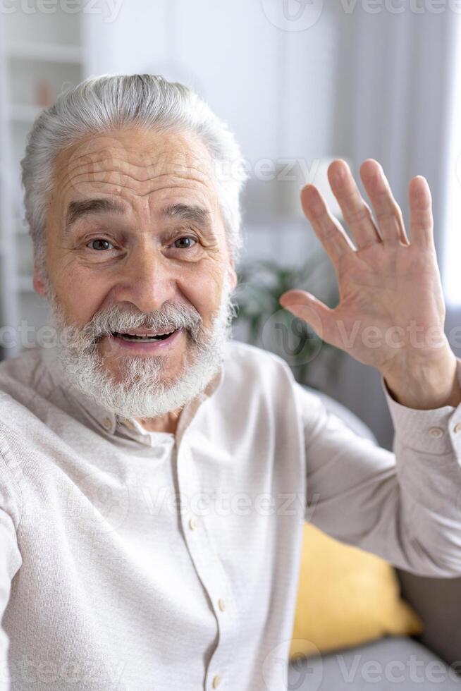 retrato do uma alegre idosos homem acenando Olá dentro uma acolhedor interior ambiente, com uma amigáveis e acolhedor expressão. foto