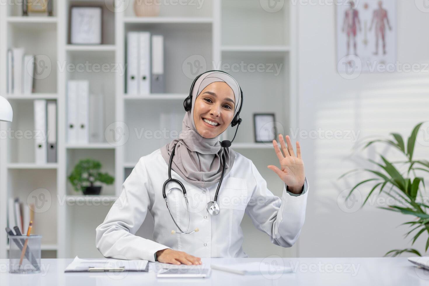 uma alegre fêmea médico dentro uma branco casaco e hijab cumprimenta calorosamente durante uma ligar a partir de dela moderno escritório. dela amigáveis comportamento e profissional configuração inspirar Confiar em e conforto. foto