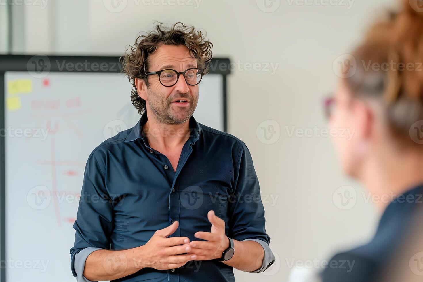 uma masculino alto falante em pé dentro frente do uma ampla cavalete dentro uma conferência sala, entregando uma Treinamento sessão para uma grupo do empresários foto