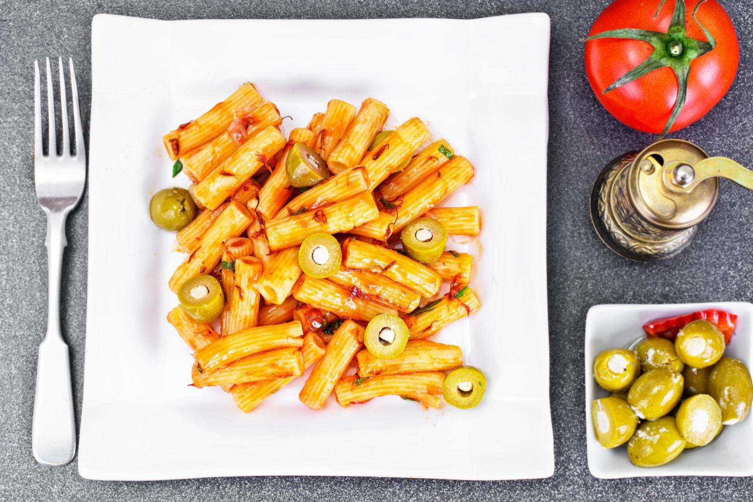 tortellini, pasna penne com ketchup e azeitonas verdes foto