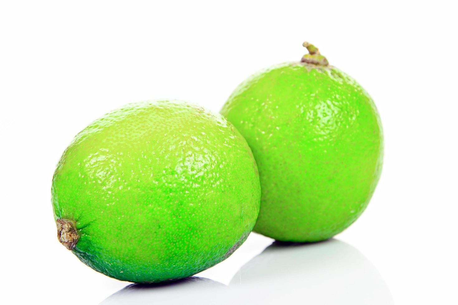 limão verde fresco em fundo branco foto