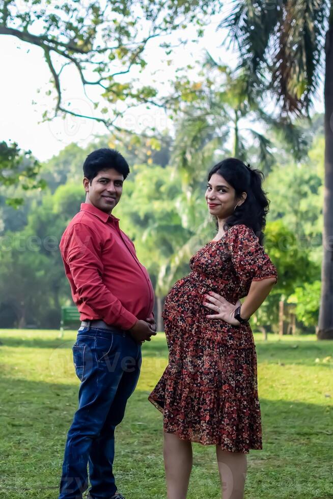 indiano casal posando para maternidade tiro pose para acolhedor Novo nascermos bebê dentro Lodhi jardim dentro Délhi Índia, maternidade foto tiro feito de pais para acolhedor seus criança, pré bebê foto tiro