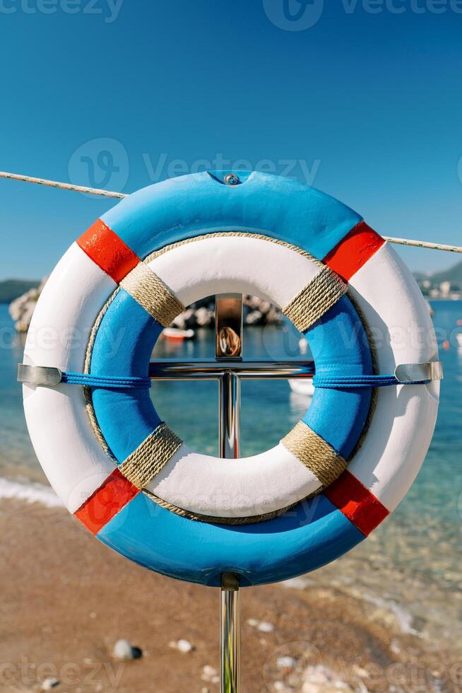 ampla e pequeno bóia salva-vidas suspensão em uma prateleira em a Beira Mar foto