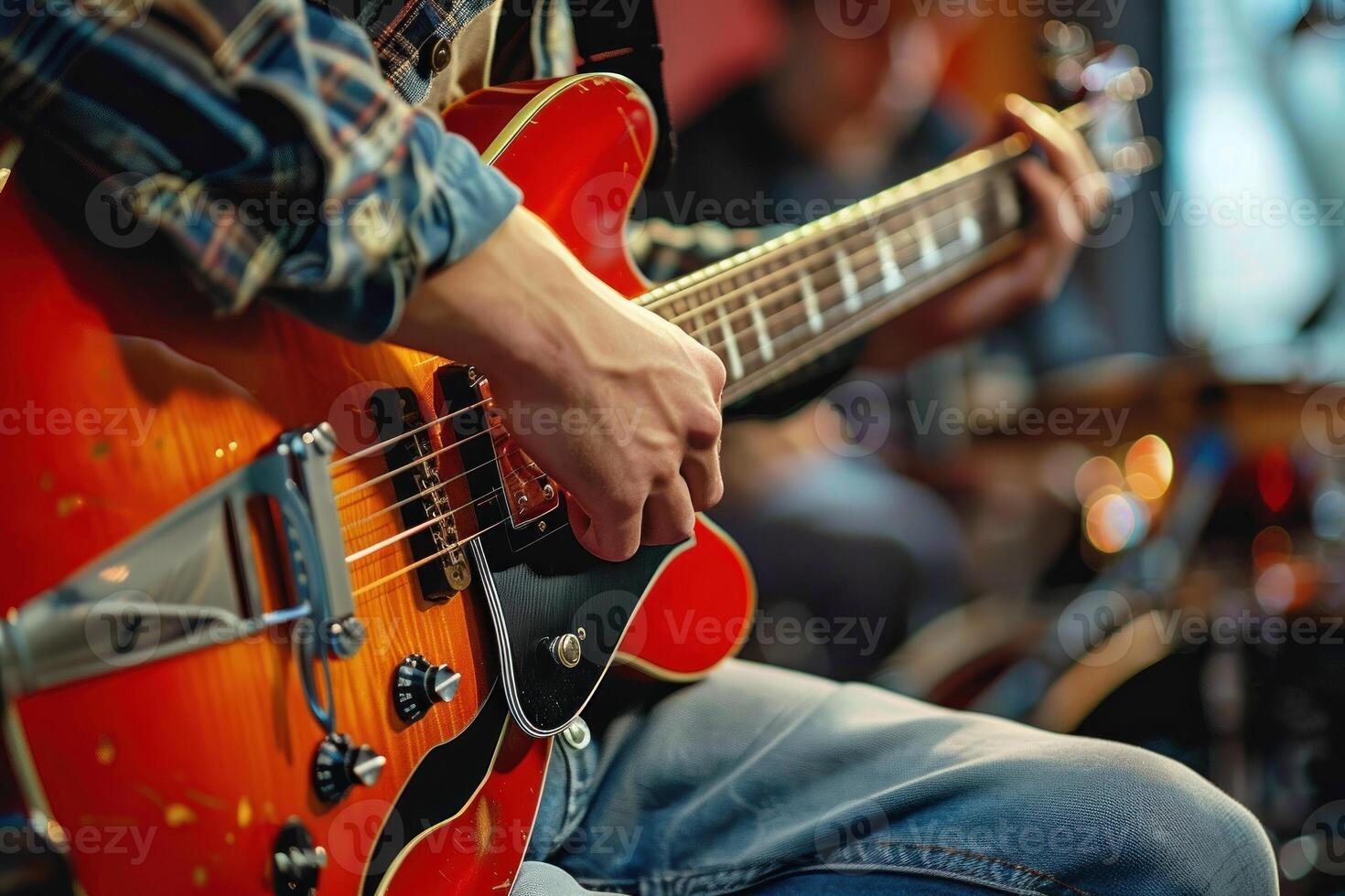 uma homem é jogando uma guitarra com dele mão em a pescoço foto