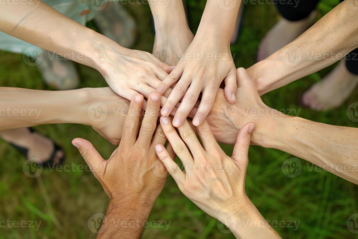 uma grupo do pessoas estão segurando mãos dentro uma círculo foto