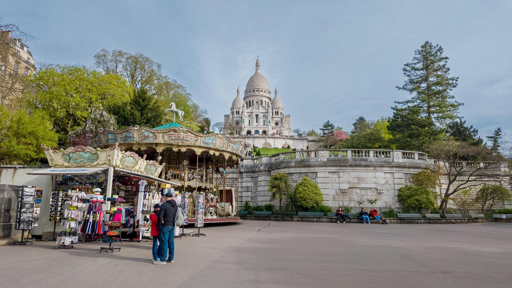 brilhante Primavera dia às Montmartre com turistas perto lembrança baias e uma vintage carrossel, sacre cur basílica dentro a pano de fundo, Paris, França, abril 14, 2024 foto