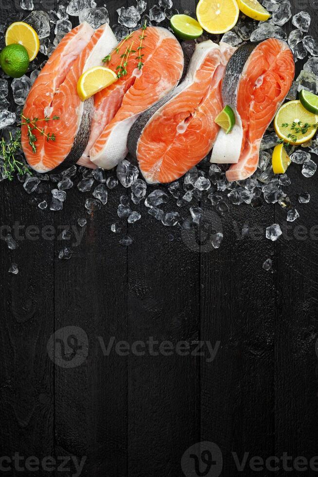 salmão bifes em gelo em Preto de madeira mesa foto