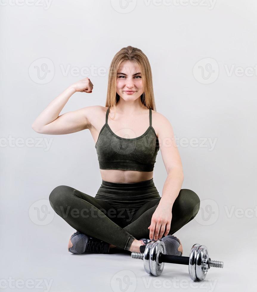 jovem apta mostrando seus braços fortes isolados em gary com espaço de cópia foto