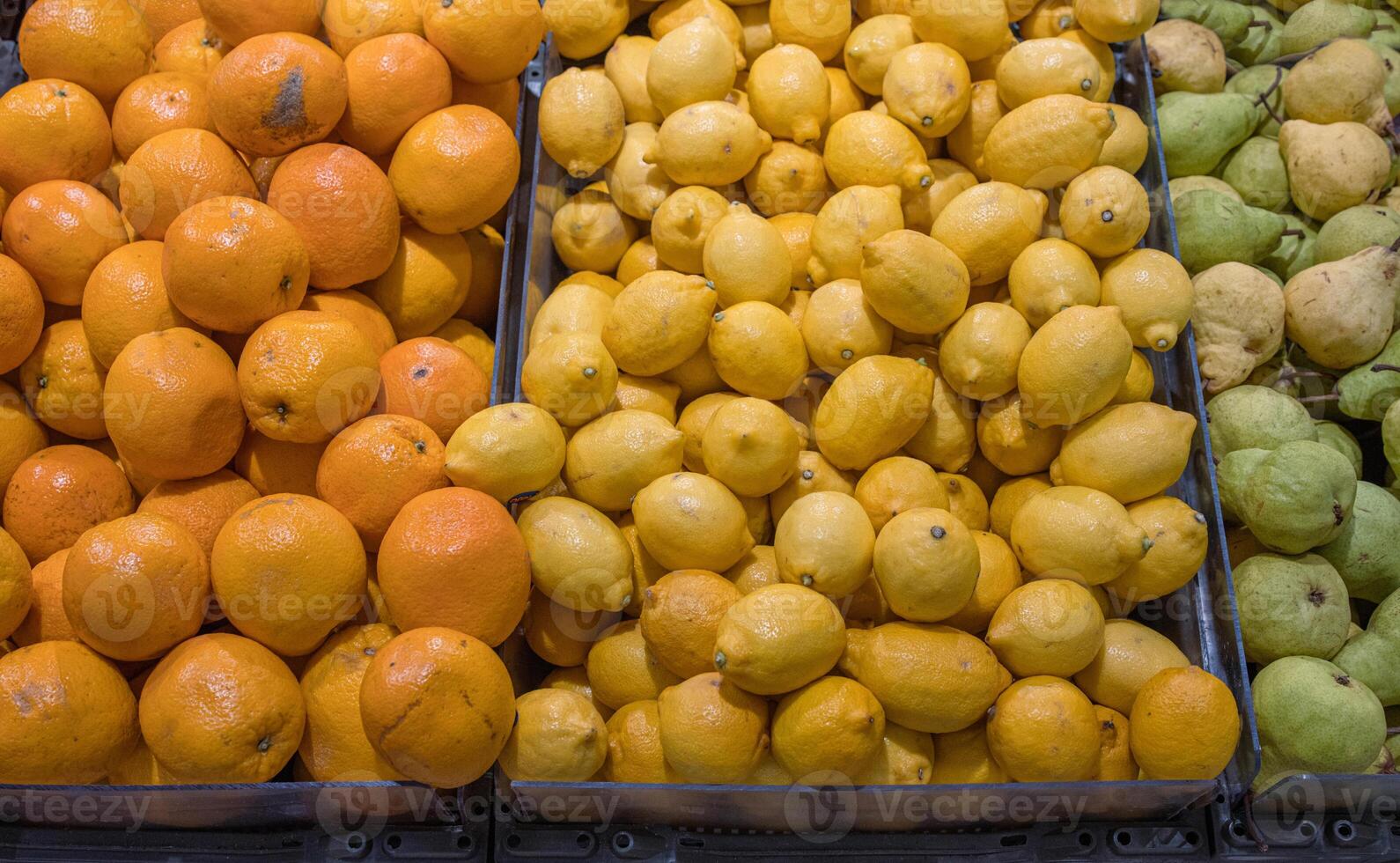 sortimento do fresco frutas arranjado dentro a mercearia loja em a contador. laranjas, limões peras, maçãs em Comida mercado prateleira. variedade do frutas vendido dentro a loja. lado visualizar. seletivo foco. foto