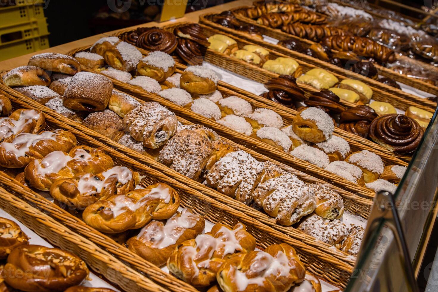 uma muitos do doce pastelaria dentro cestas em a contador dentro a Comida loja. padaria em a bufê mesa. o negócio café da manhã e refeições às eventos. vários pão tipo em prateleira. fechar-se. seletivo foco. foto