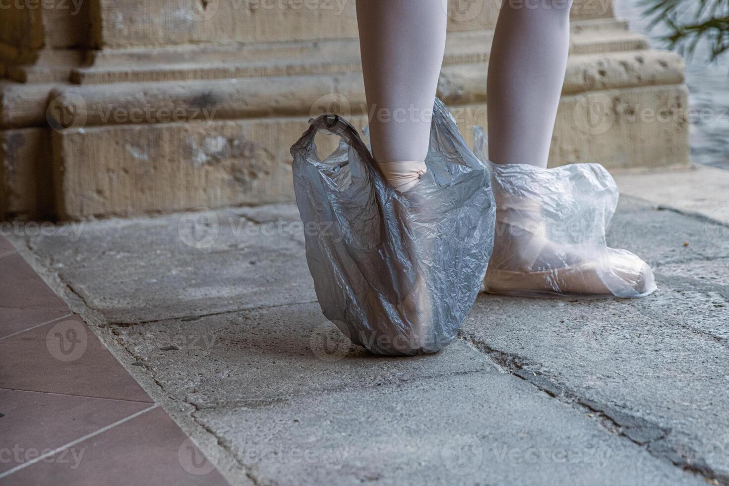 balé artista em pé em dela dicas enquanto vestindo plástico bolsas em dela sapato. plástico bolsas estão protegendo ponta sapatos em a rua. Novo usar do plástico. preparativos para desempenho. nos bastidores. foto