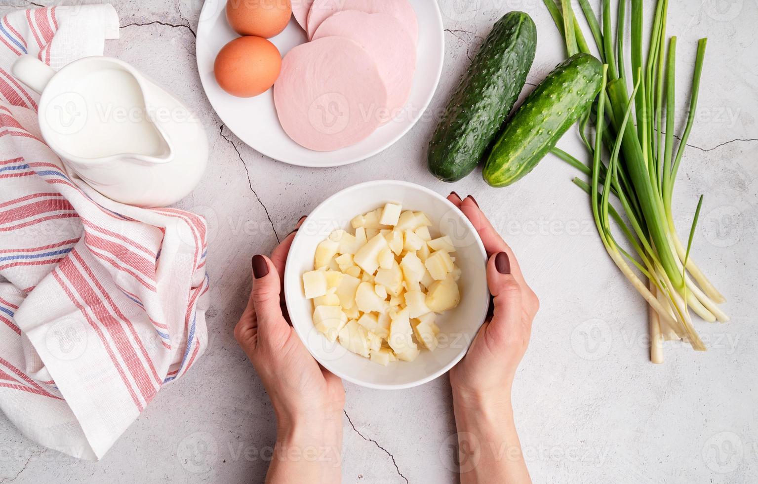 passo a passo preparação de sopa fria de okroshka com salsicha, passo 2 - batatas cozidas picadas em uma tigela vista de cima foto