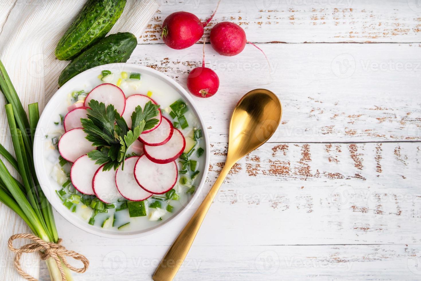 okroshka. sopa tradicional russa com rabanete, pepino e cebola verde, espaço de cópia com vista superior foto