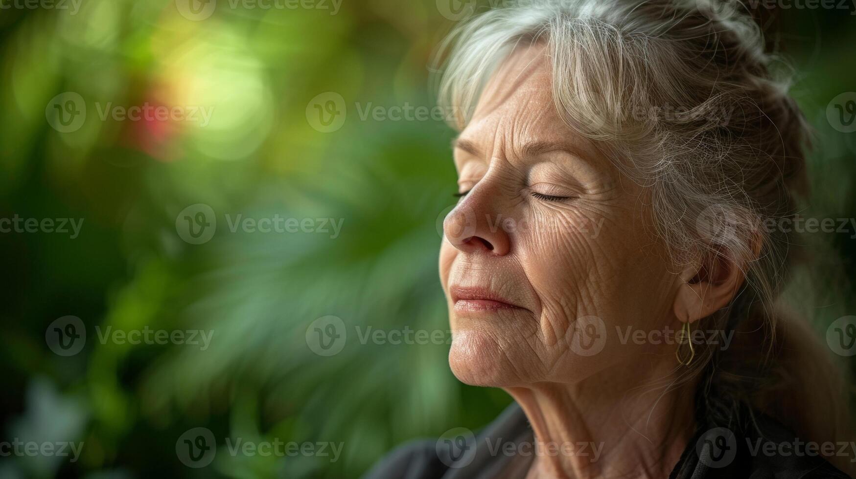 uma fechar-se do uma Senior mulher face Como ela participa dentro uma guiado respiração exercício dela expressão sereno e dela mente centrado com uma pano de fundo do calmante vegetação foto