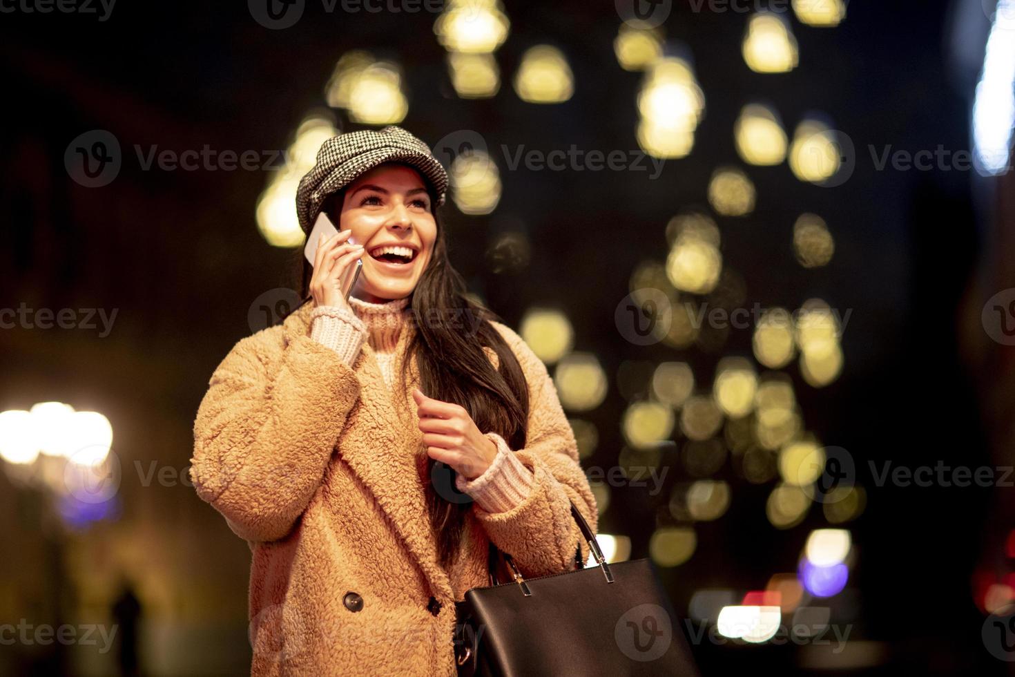 bela jovem usando o celular na rua na época do natal foto