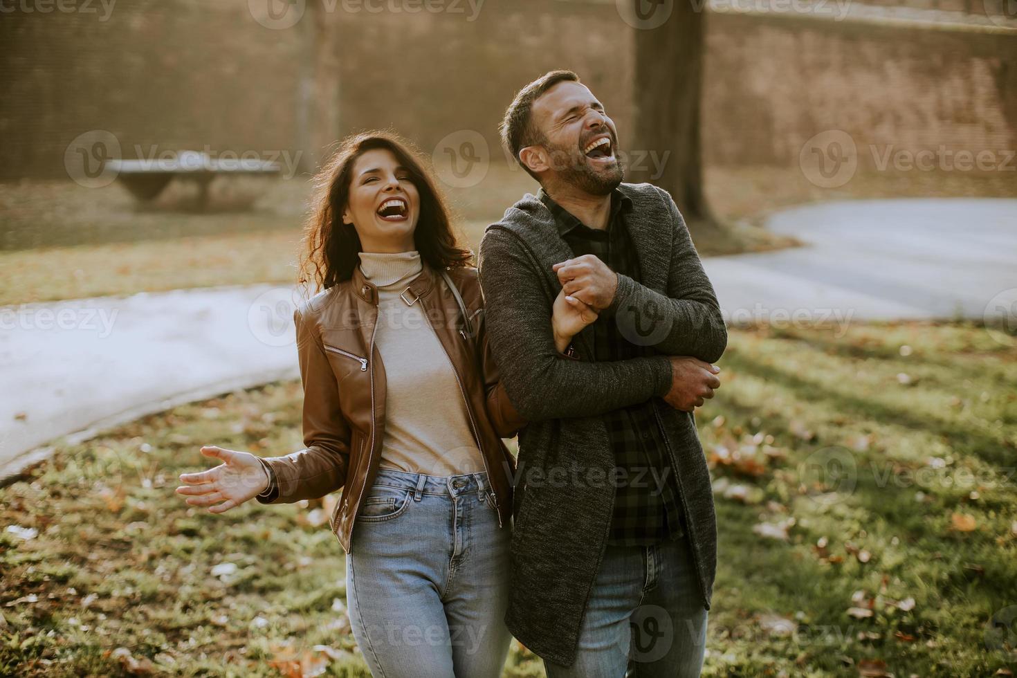 jovem casal feliz caminhando no parque outono foto