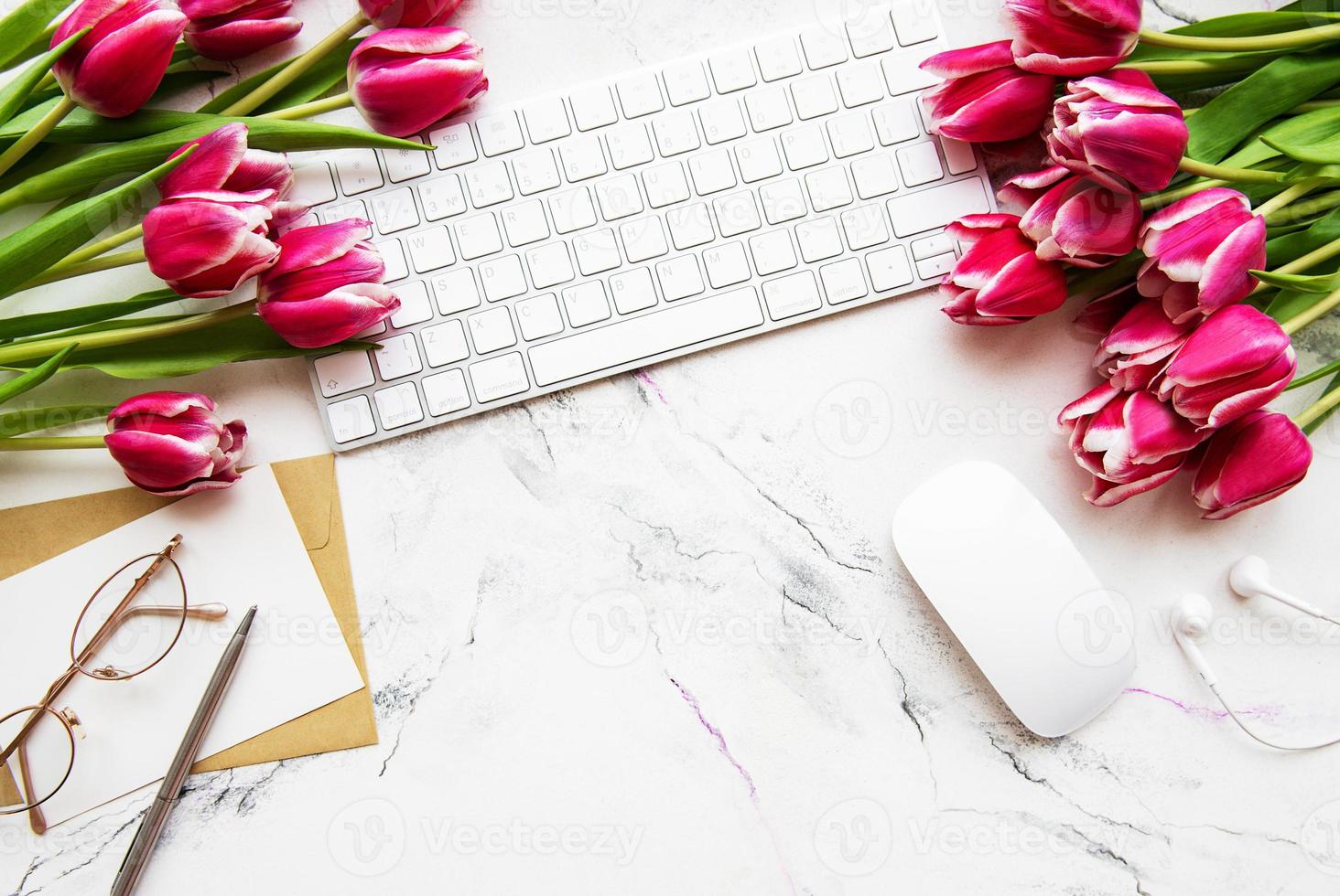 espaço de trabalho com teclado e tulipas foto