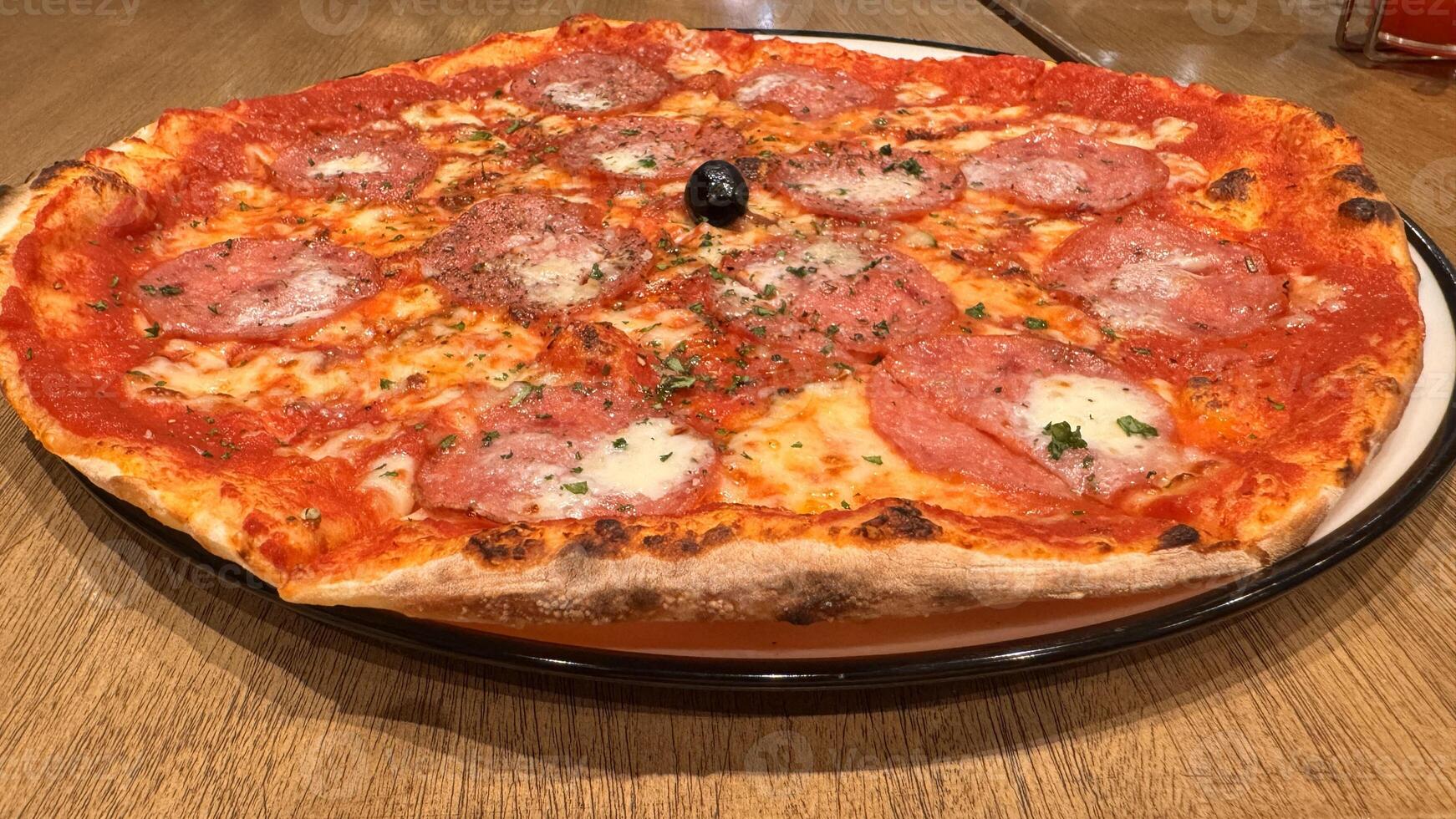 recentemente cozido Novo Iorque estilo pizza com derretido mozzarella queijo e base tomate molho com grande quantidade do calabresa foto