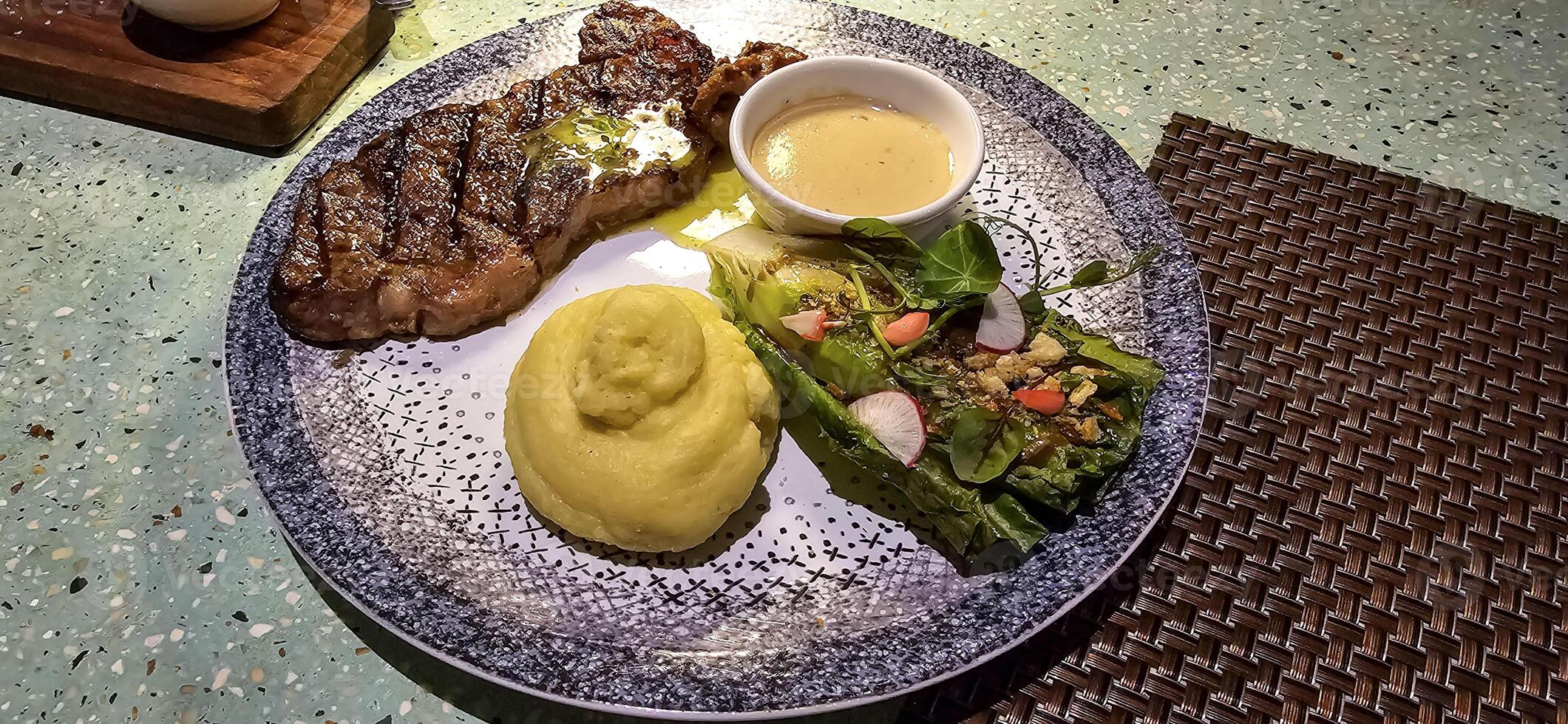 carne Novo Iorque faixa lombo bife ou lombo bife servido com batatas, e cogumelo molho e salada em prato foto