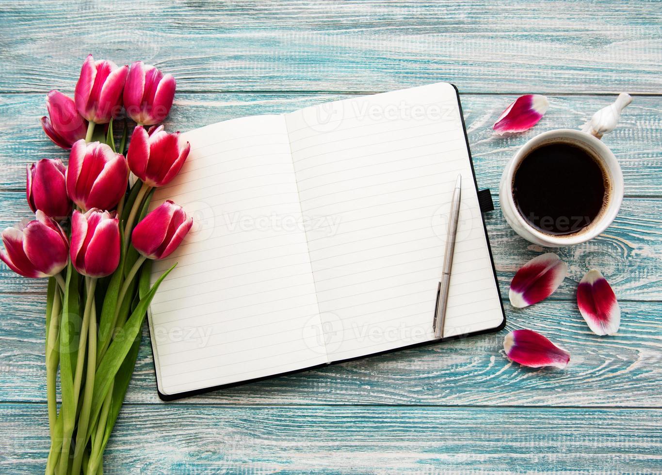 caderno, xícara de café e tulipas cor de rosa foto