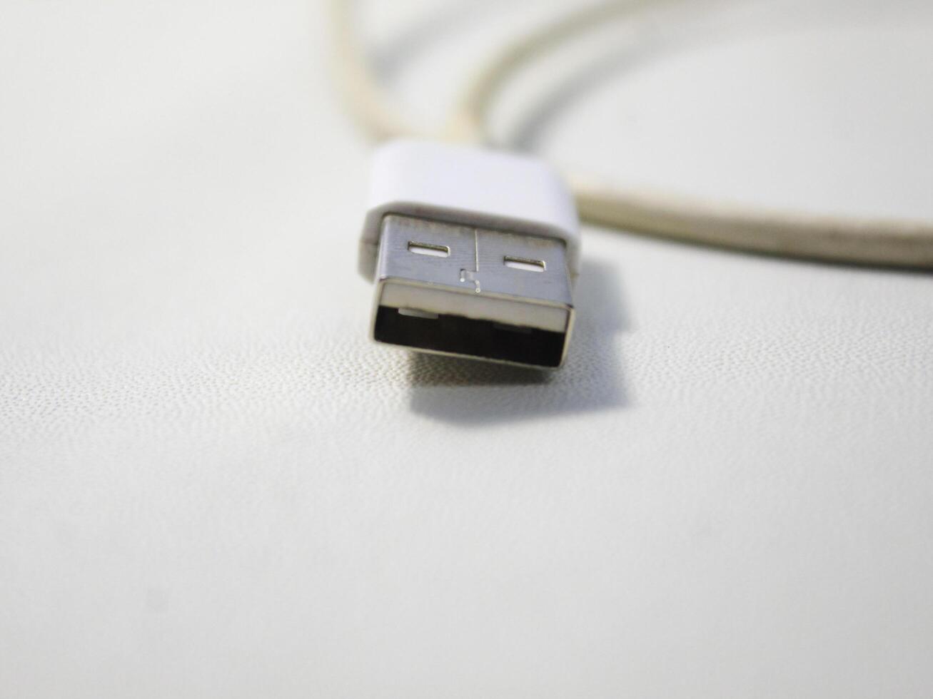 fechar acima a branco quebrado Smartphone USB cabo em branco de madeira fundo. foto