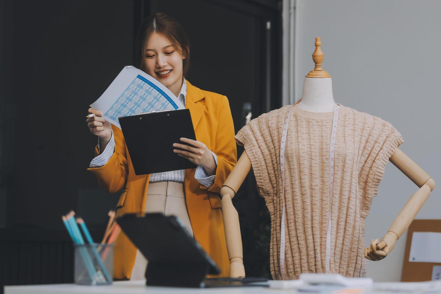 retrato lindo sorrir ásia desenhador mulher usar computador dentro alfaiate tecido moda pequeno o negócio conectados oficina. jovem proprietário comece empreendedor. criativo menina têxtil vestuário sme o negócio conceito foto