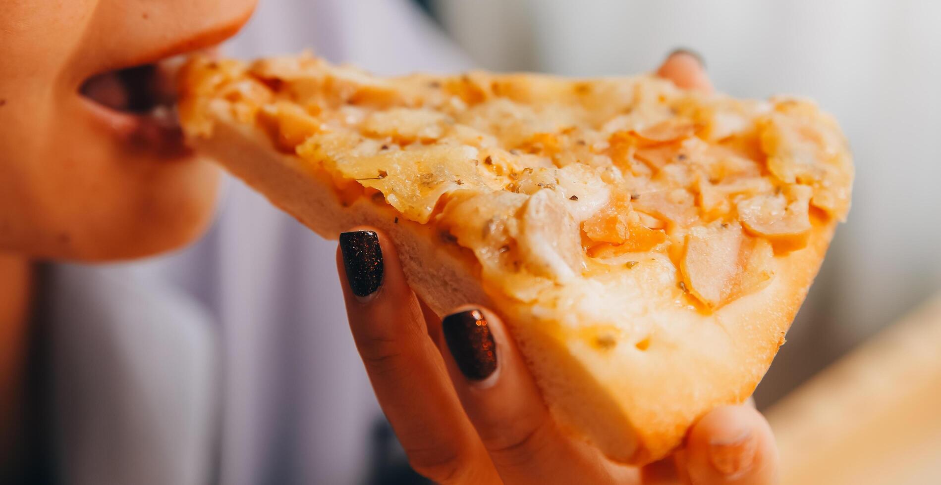 cortada imagem do mulher segurando pizza fatia às restaurante foto