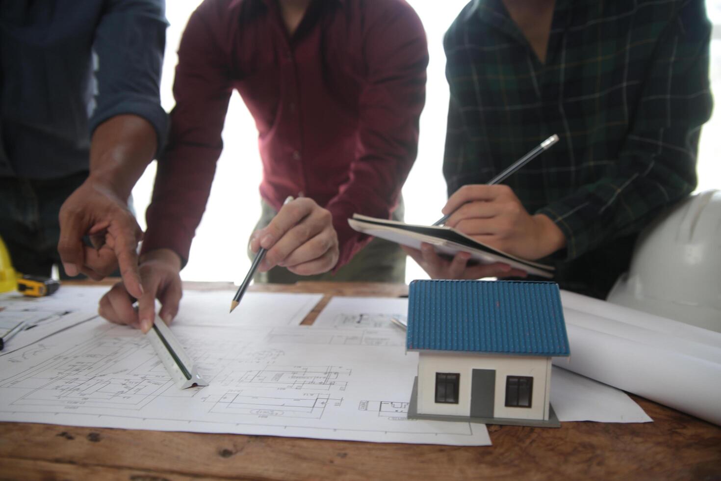 conceito de construção e estrutura de reunião de engenheiro ou arquiteto para projeto trabalhando com parceiros e ferramentas de engenharia na construção de modelo e projeto no local de trabalho, contrato para ambas as empresas. foto