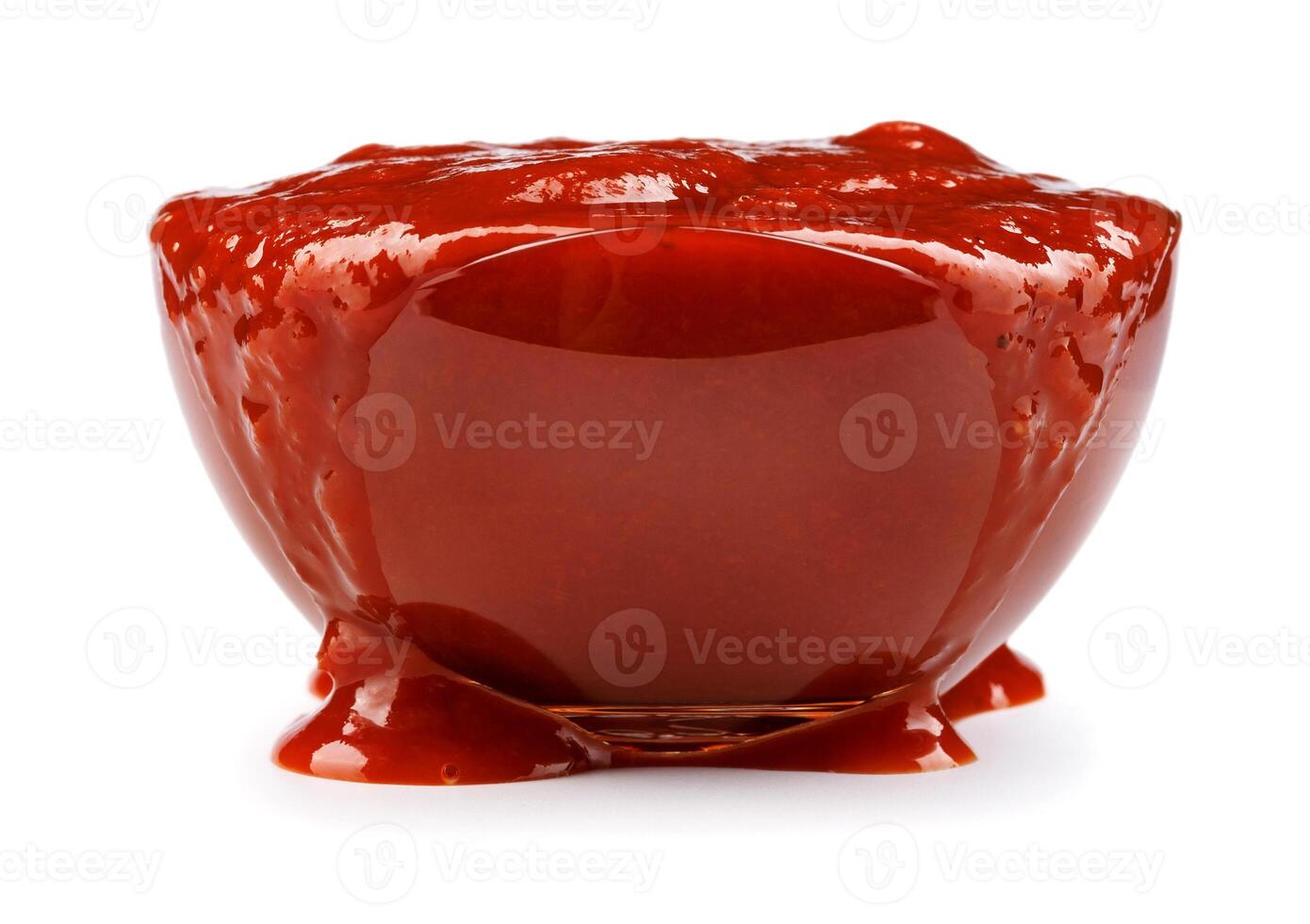 ketchup dentro uma vidro copo isolado em uma branco fundo. tomate molho transbordar sobre a Beira do uma vidro tigela. foto