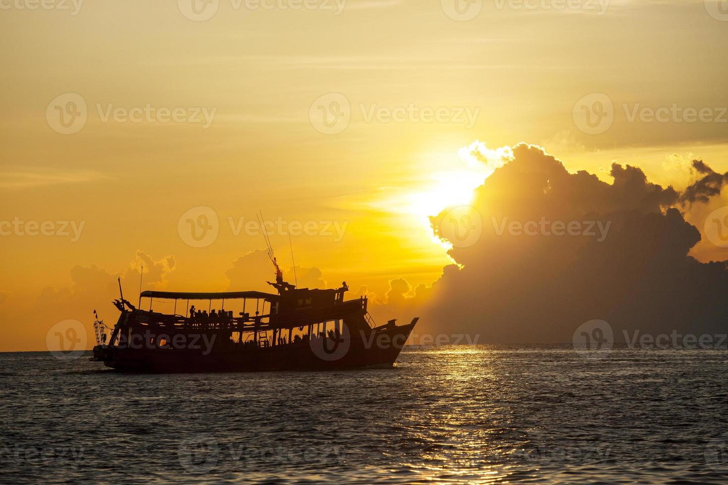 fotografia de silhueta de lindo céu ao pôr do sol e barco de mergulho turístico foto