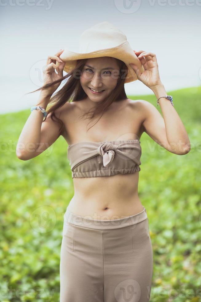 retrato da bela jovem asiática, rosto sorridente com emoção de felicidade na praia do mar foto