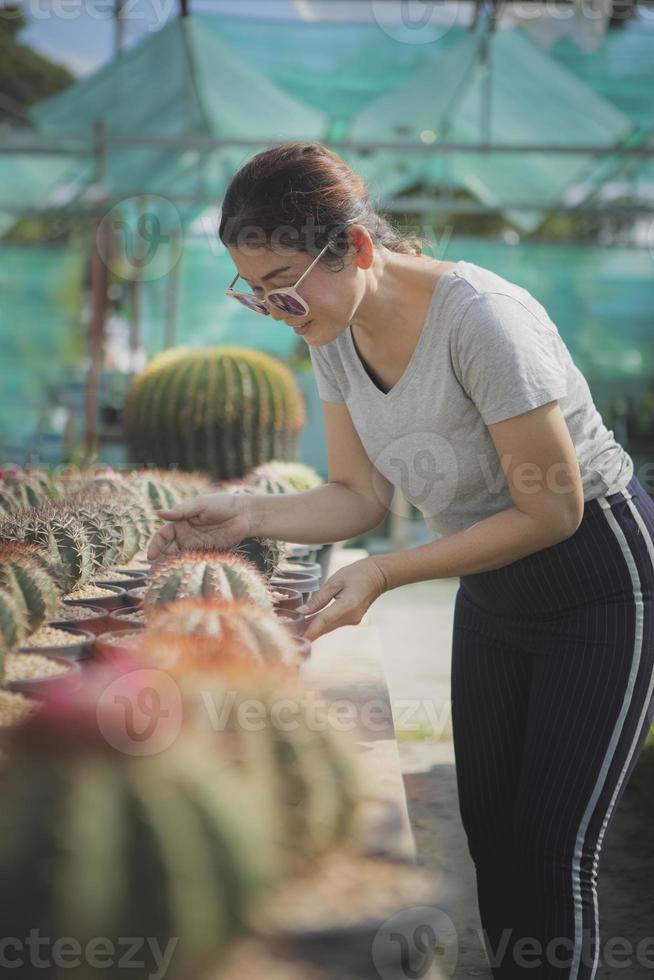 mulher asiática cuidando de um vaso de plantio no jardim de cactos foto