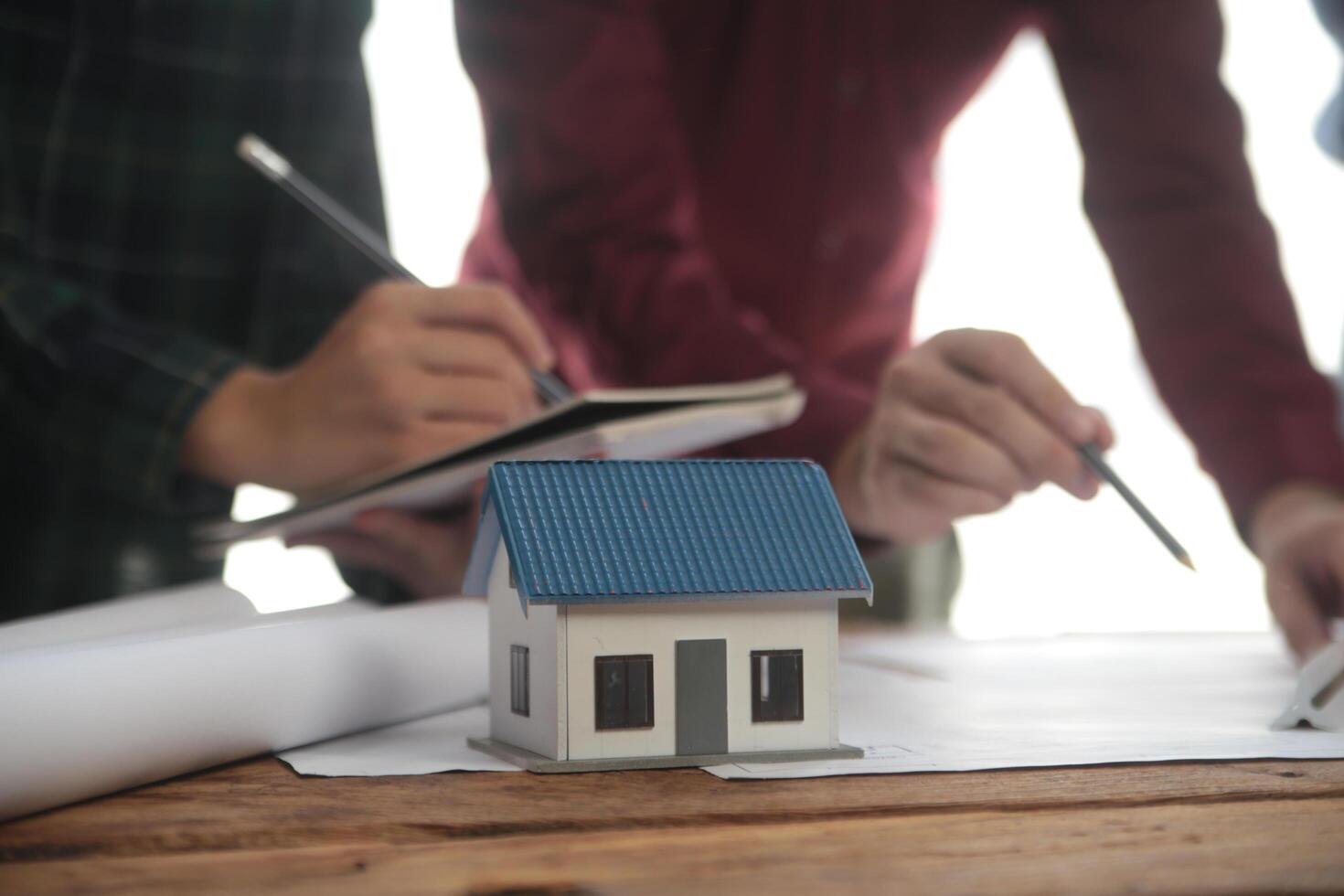 conceito de construção e estrutura de reunião de engenheiro ou arquiteto para projeto trabalhando com parceiros e ferramentas de engenharia na construção de modelo e projeto no local de trabalho, contrato para ambas as empresas. foto