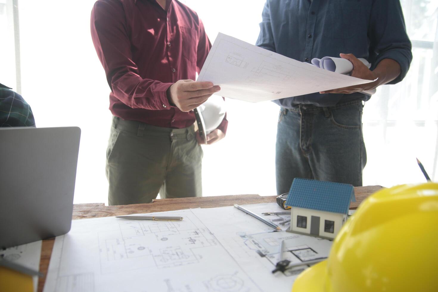 diverso equipe do especialistas usar computador portátil em construção local. real Estado construção projeto com engenheiro investidor e homem de negocios verificação área, trabalhando em Civil Engenharia, discutindo estratégia plano foto