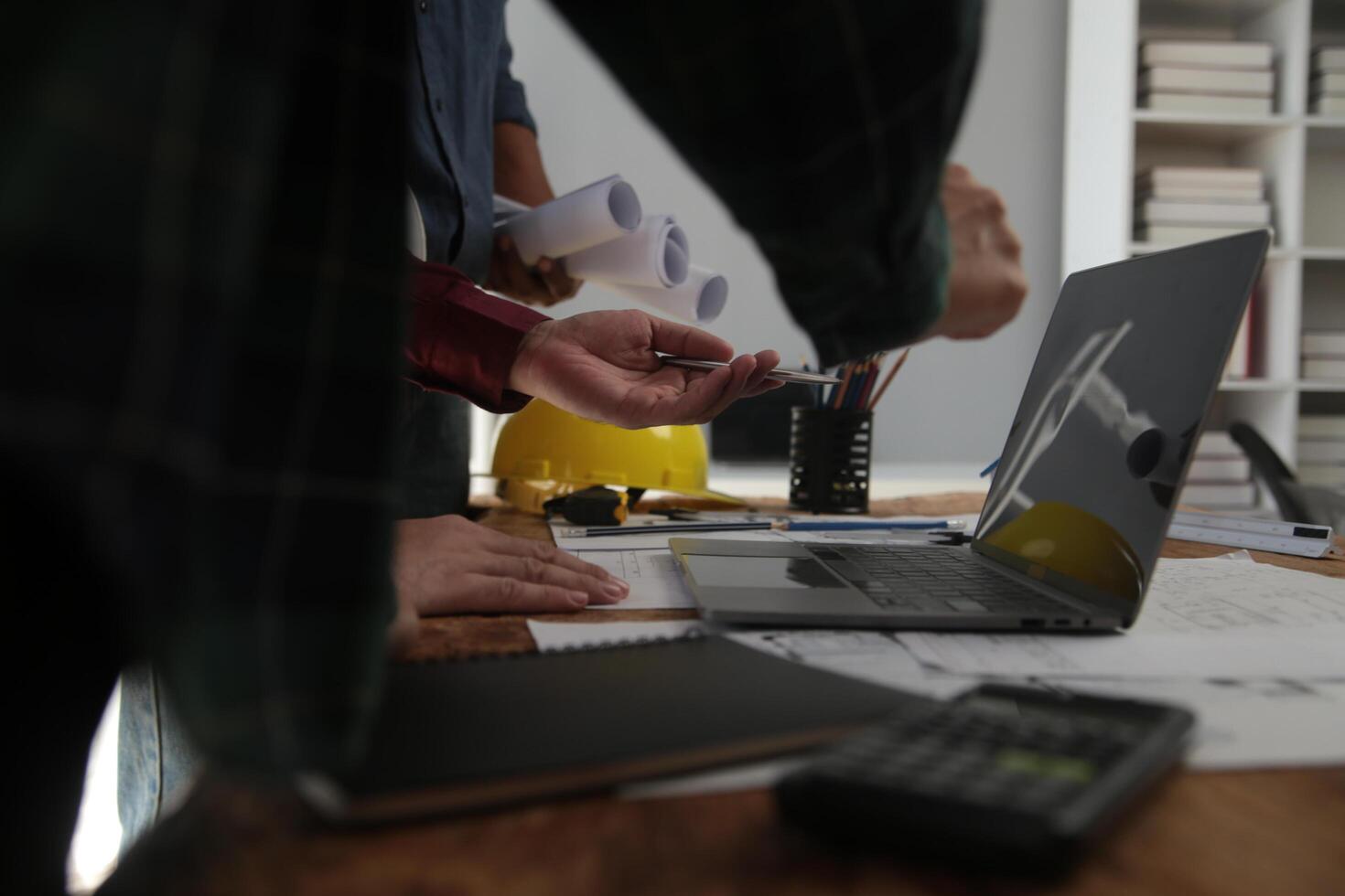 engenheiros estão consultando a equipe para Projeto a arquitetônico estrutura para clientes com plantas e construção modelos para trabalhos às escritório. foto