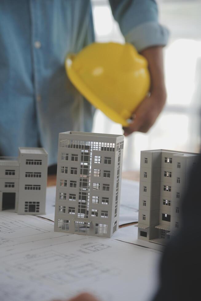 conceito de construção e estrutura de reunião de engenheiro ou arquiteto para projeto trabalhando com parceiros e ferramentas de engenharia na construção de modelo e projeto no local de trabalho, contrato para ambas as empresas. foto