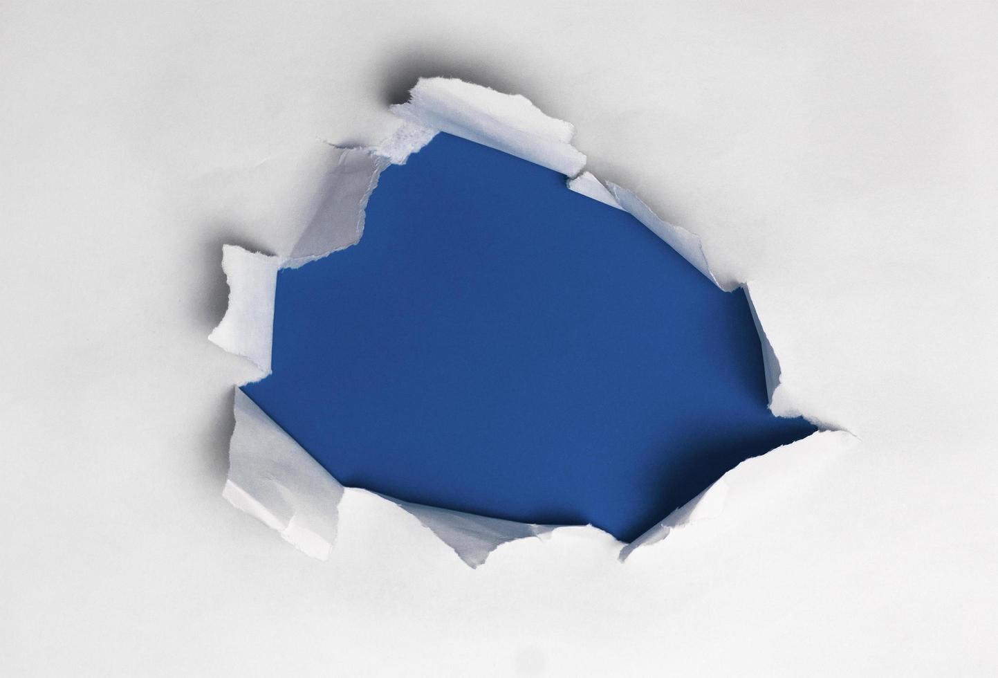 papel rasgado branco em fundo azul foto