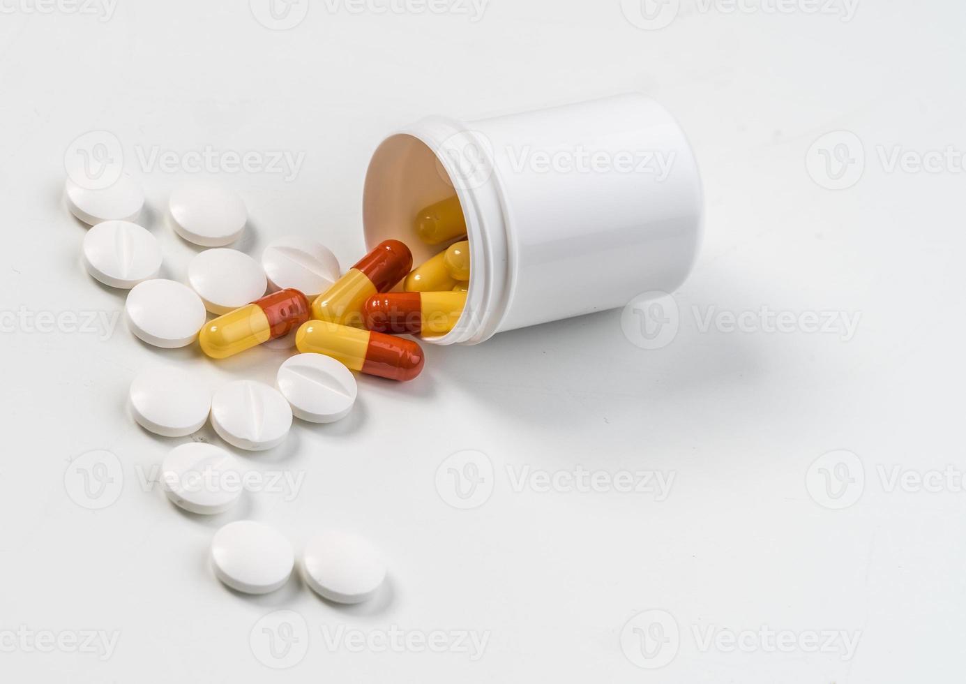 comprimido de medicamento branco e laranja na superfície branca foto
