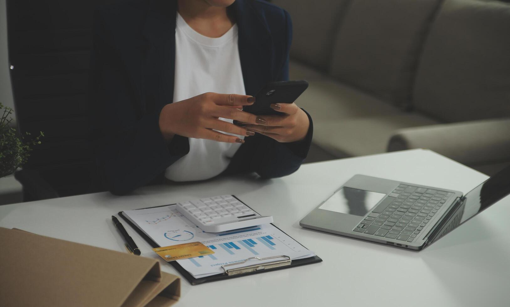 jovem feliz empresária usando computador dentro moderno escritório com colegas. à moda lindo Gerente sorridente, trabalhando em financeiro e marketing projetos. bebendo chá ou café a partir de uma caneca. foto