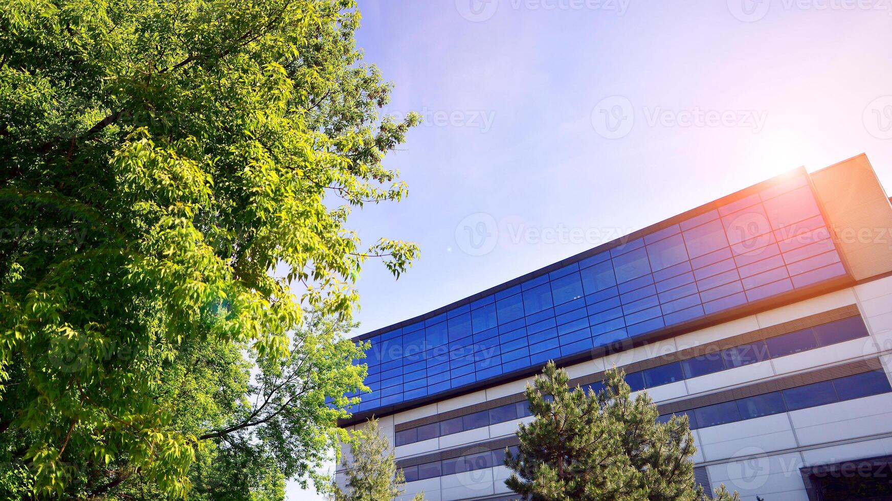 sustentável vidro escritório construção com árvores para reduzindo carbono dióxido. ecológico construção dentro moderno cidade. escritório com verde ambiente. corporativo construção reduzir co2. foto