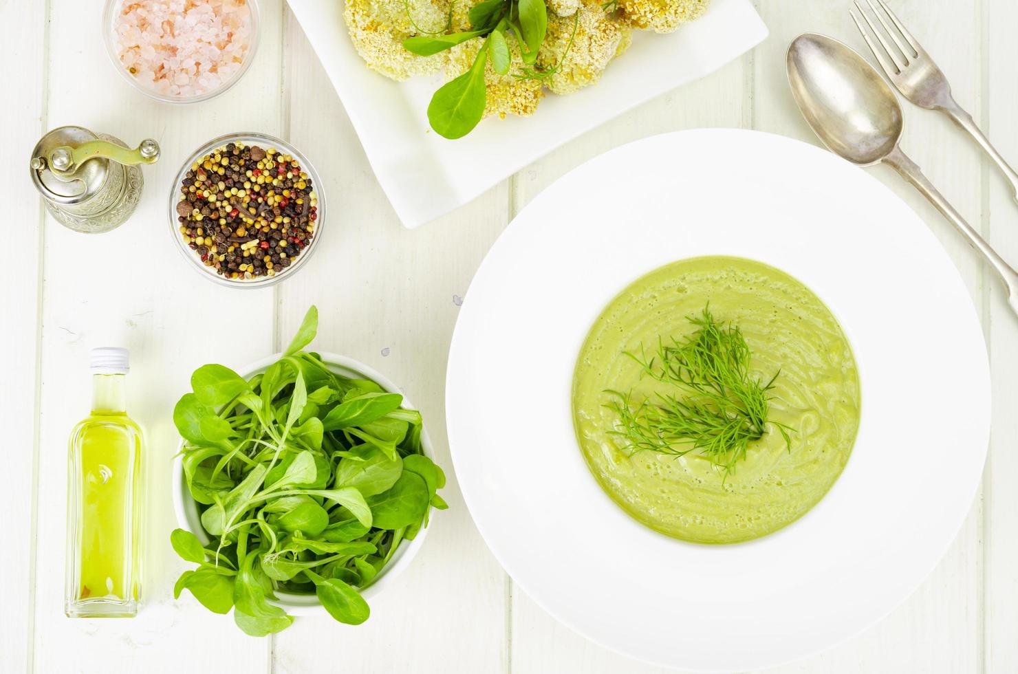 prato branco com sopa de creme de vegetais verdes, prato de dieta saudável. foto