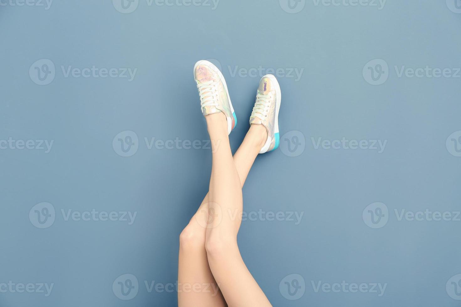 pernas de mulher bonita em sapatos elegantes na cor de fundo foto
