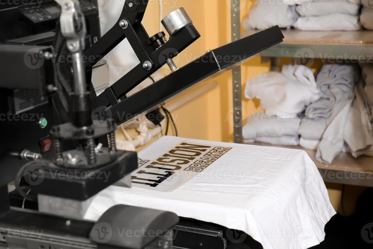 máquina de impressão moderna com camiseta no local de trabalho foto
