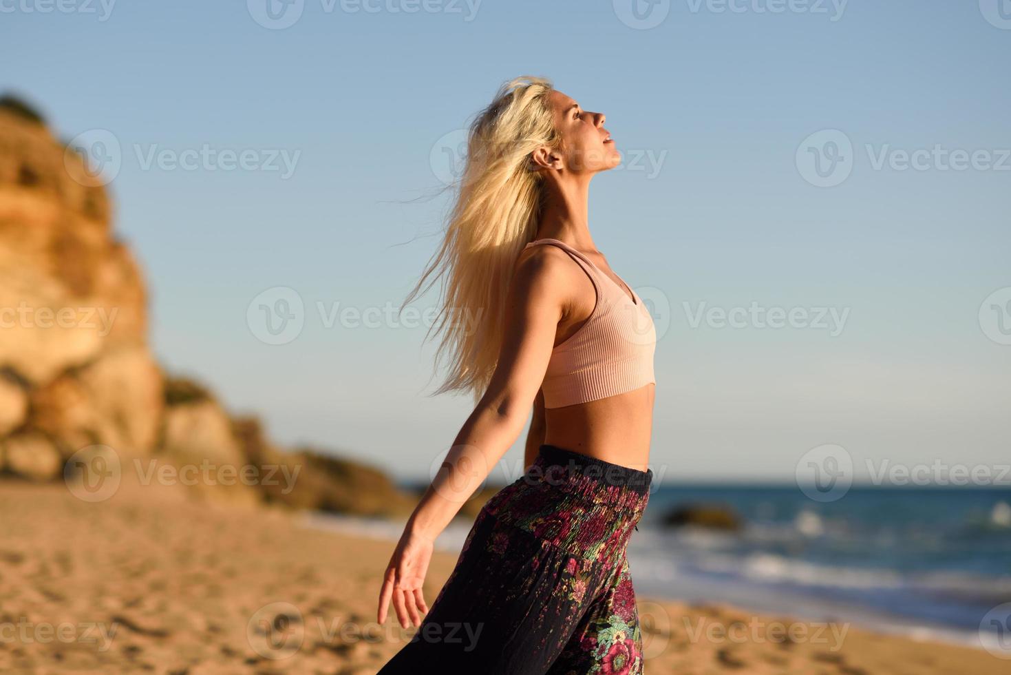 mulher curtindo o pôr do sol em uma bela praia foto