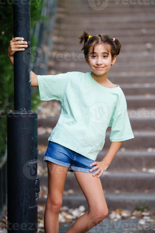 menina de nove anos em pé na escada ao ar livre foto