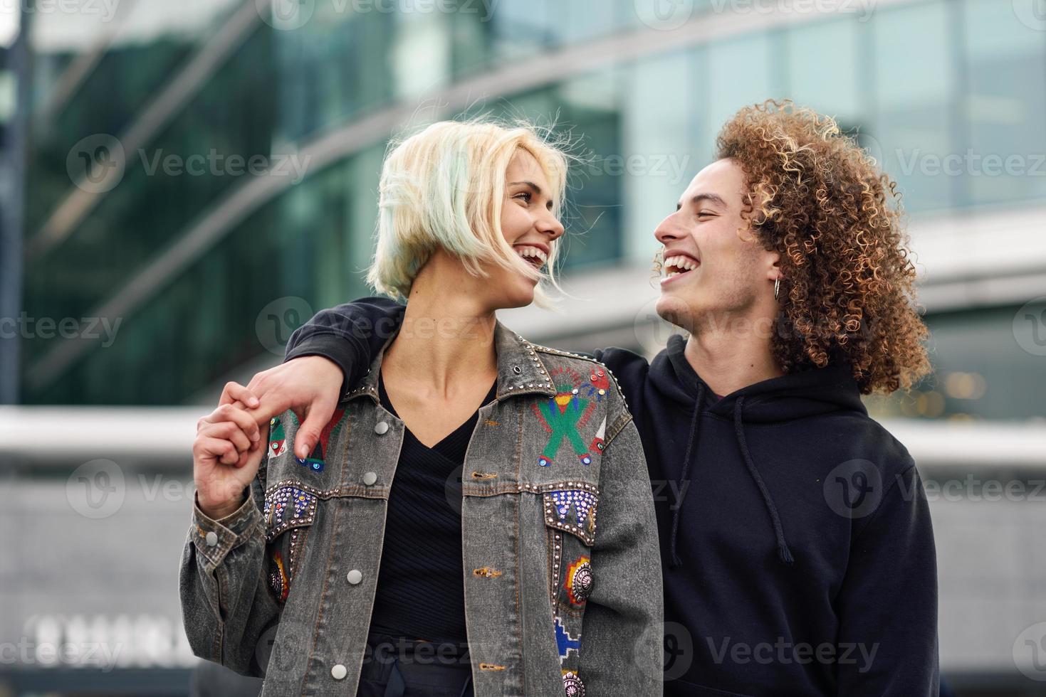 jovem casal feliz rindo em meio urbano foto