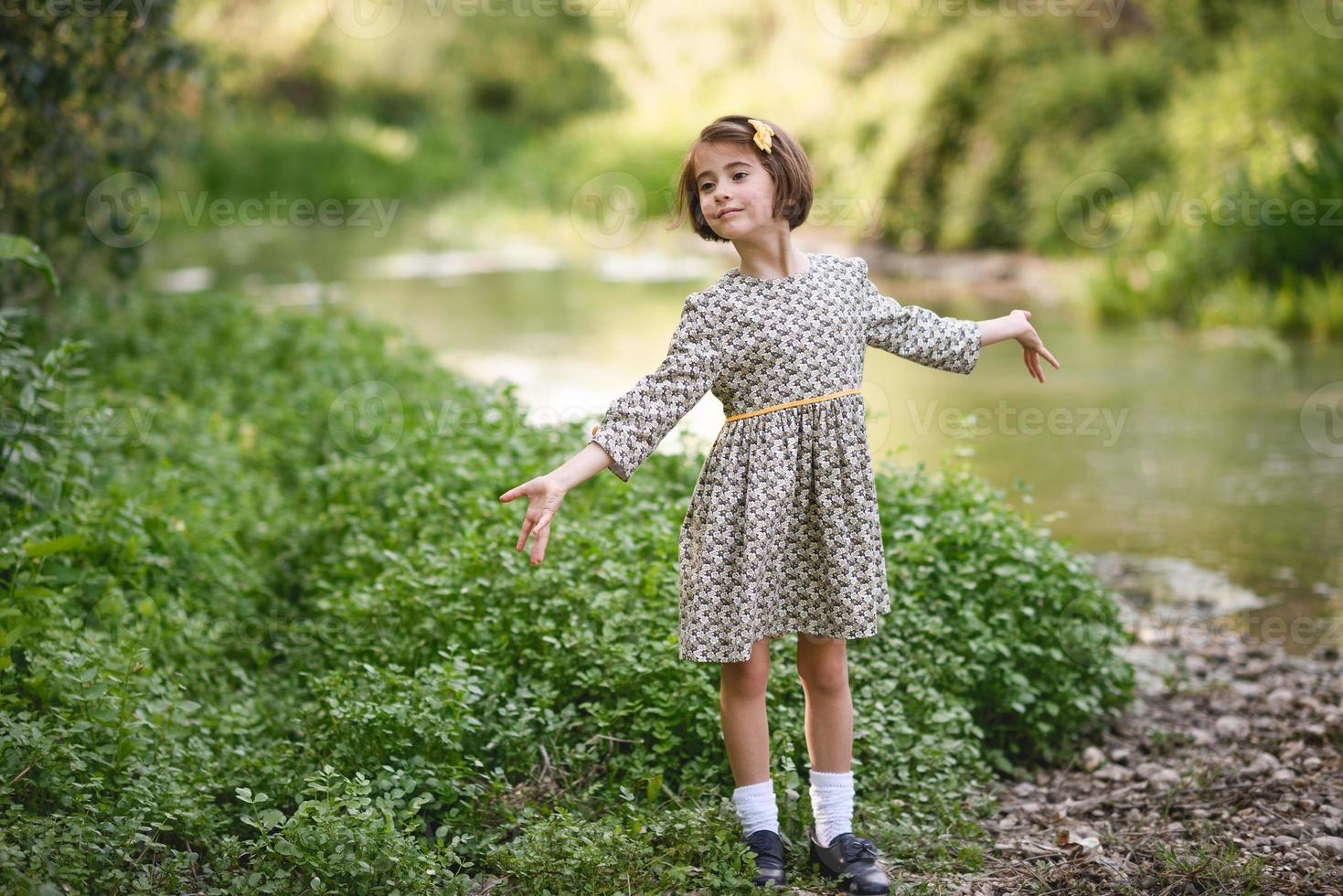 menina no riacho da natureza com um lindo vestido foto