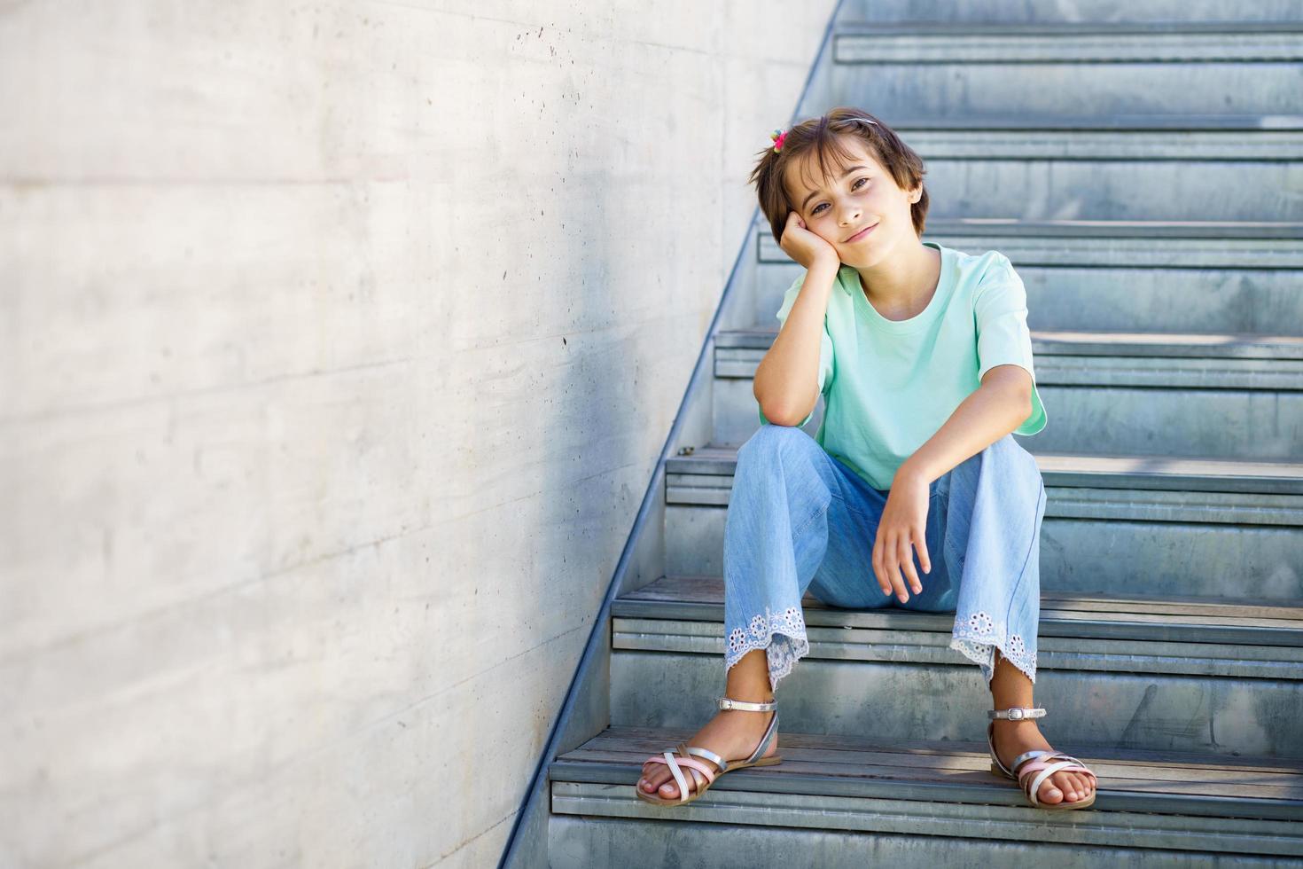 Menina de 9 anos posando feliz em uma escada foto