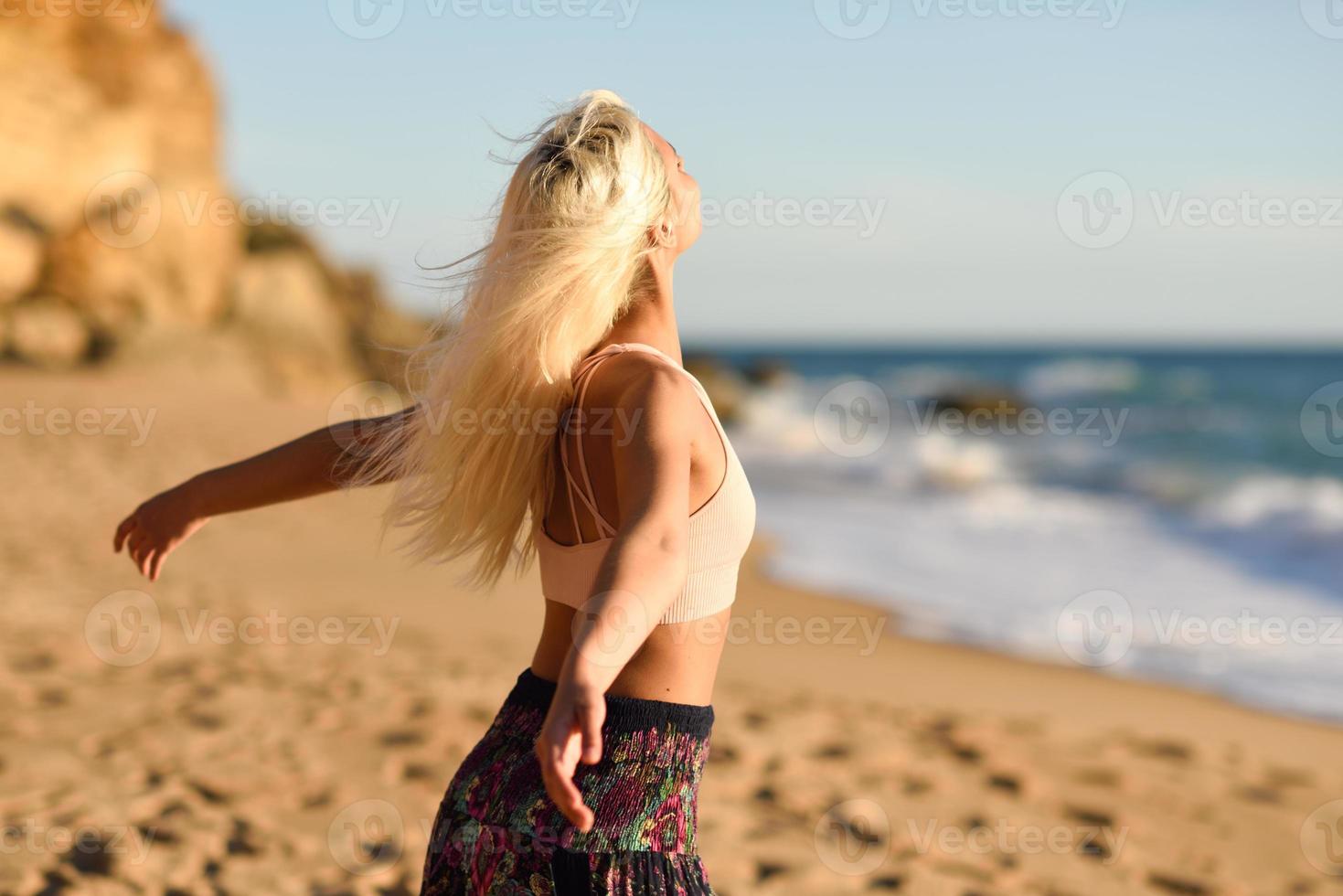 mulher curtindo o pôr do sol em uma bela praia foto