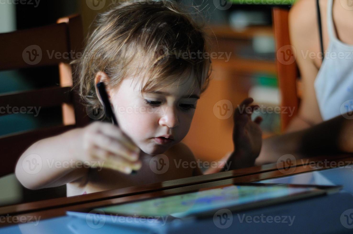 menina pintando com um tablet digital em casa. foto